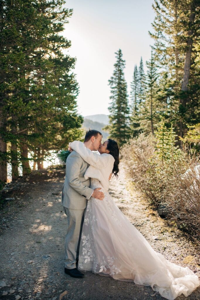 bride and groom kissing in the forest during their breckenridge elopement after their self-solemnization ceremony