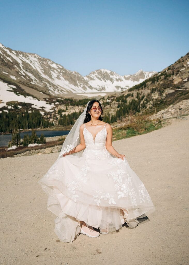 bride spinning around in her wedding dress with the mountains in the background during her self-solemnization ceremony in breckenridge colorado