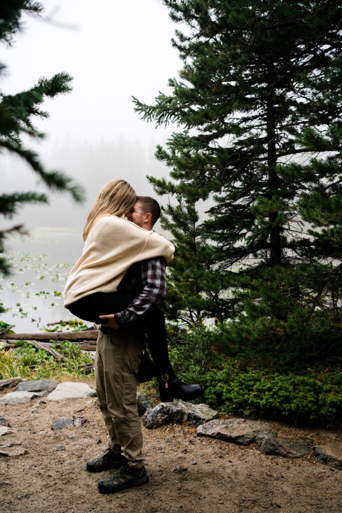wife jumping on husband during their rocky mountain national park engagement session