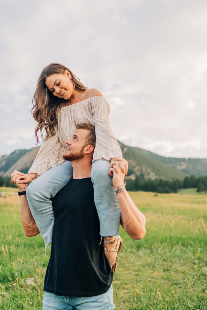 boyfriend giving his girlfriend a shoulder ride during their couples photoshoot in boulder colorado at chautauqua park