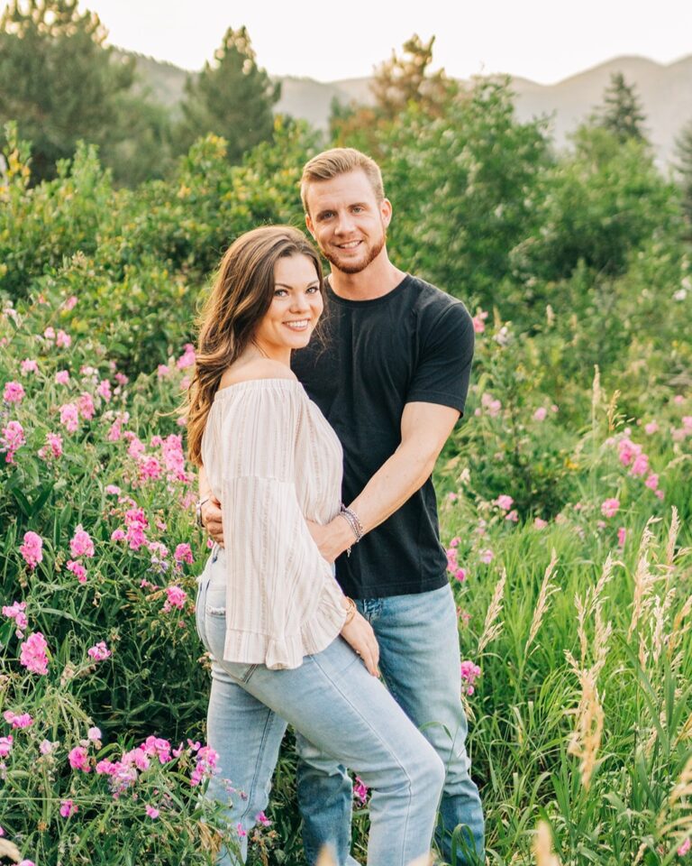 cute couple standing in a field of flowers at chautauqua park during their bouder colorado couples session