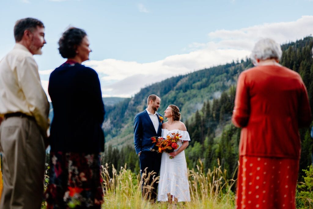 bride and groom holding eachother during their ceremony as their families read statements during their ceremony at their eldora mountain colorado elopement