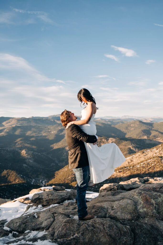 grooming holding bride up over his head during sunset at Lost Gulch Overlook in Colorado during their boulder elopement