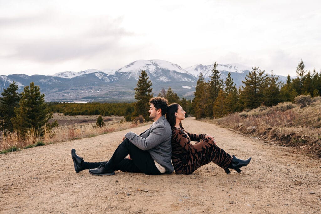Couple sitting back-to-back on a road near Sapphire Point Overlook in Breckenridge, Colorado