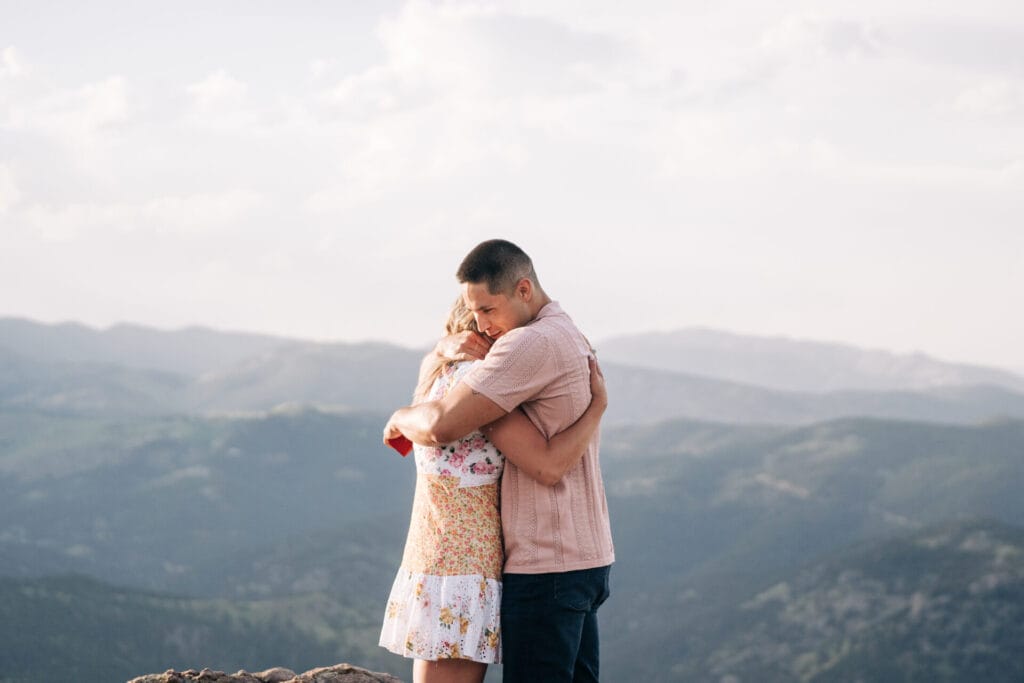 Couple embracing with mountains in background.