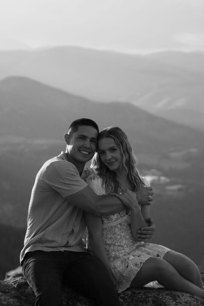 Couple embracing with mountain view in background during their proposal at Lost Gulch Overlook in Boulder, Colorado