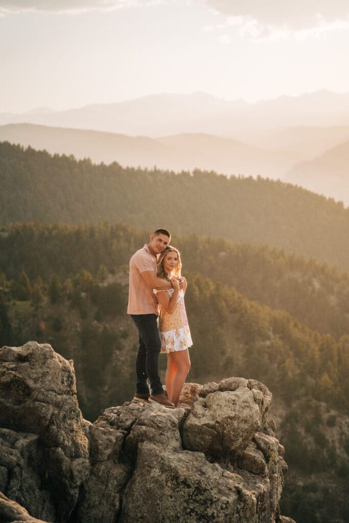 Couple embracing on cliff at Lost gulch overlook in boulder, colorado after their sunset proposal