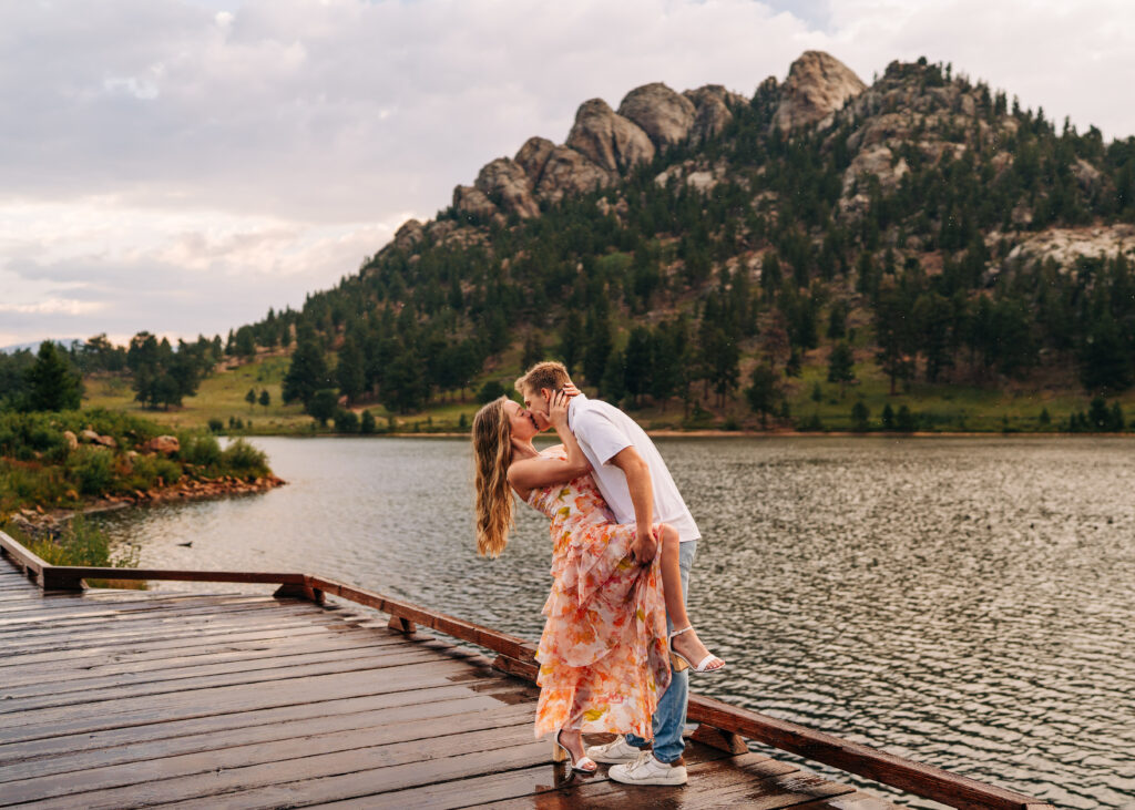 boyfriend dipping his girlfriend while kissing her on a boardwalk during their lily engagement photos
