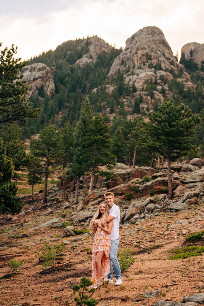 boyfriend hugging his girlfriend from behind in the forest during their lily lake engagement photos
