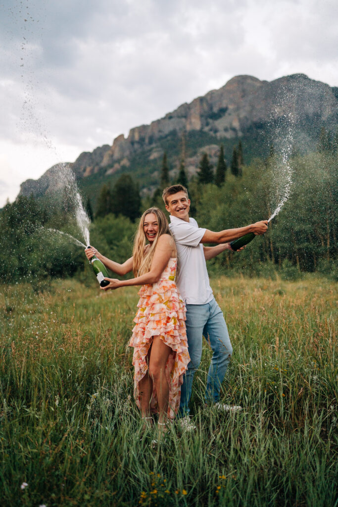 cute couples back to back spraying champagne to celebrate during their lily engagement photos