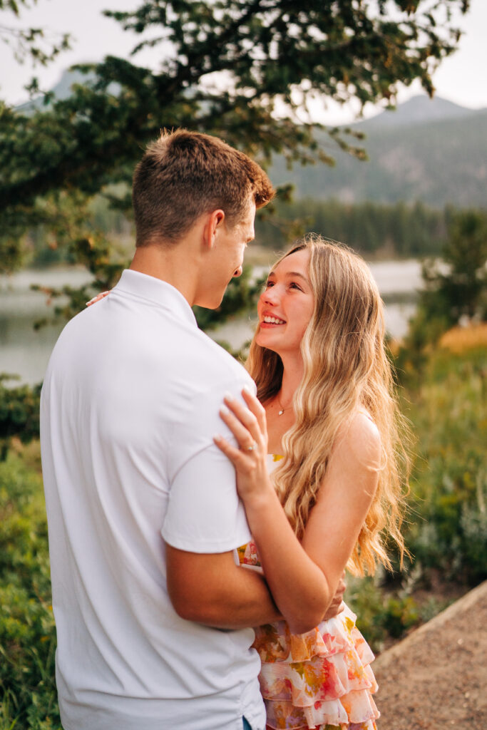 girlfriend smiling and hugging her boyfriend during their lily lake engagement photos 