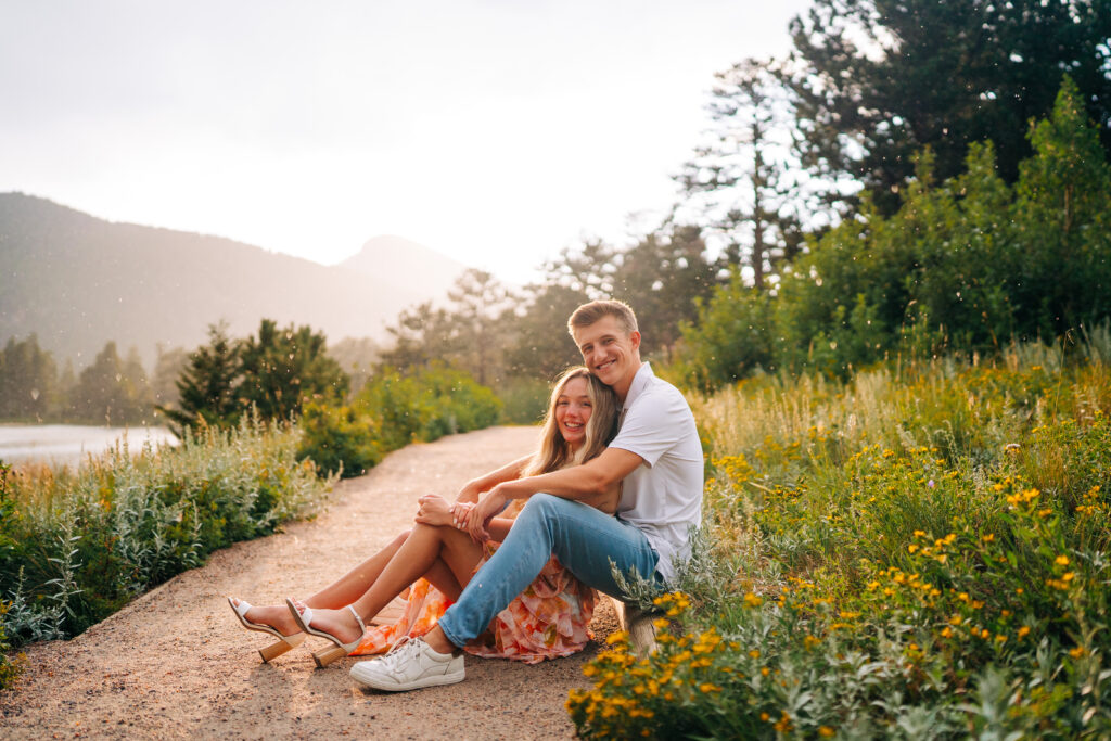 boyfriend and girlfriend sitting on a path together during their lily lake engagement photos