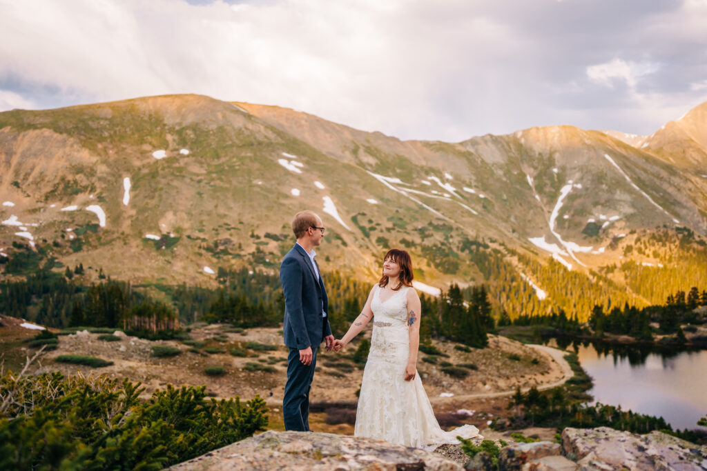 bride and groom holding hands smiling at eachother during their loveland pass elopement