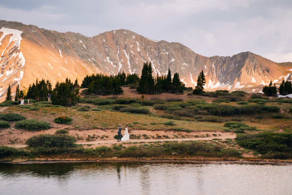 bride and groom walking by an alpine lake during their loveland pass elopement