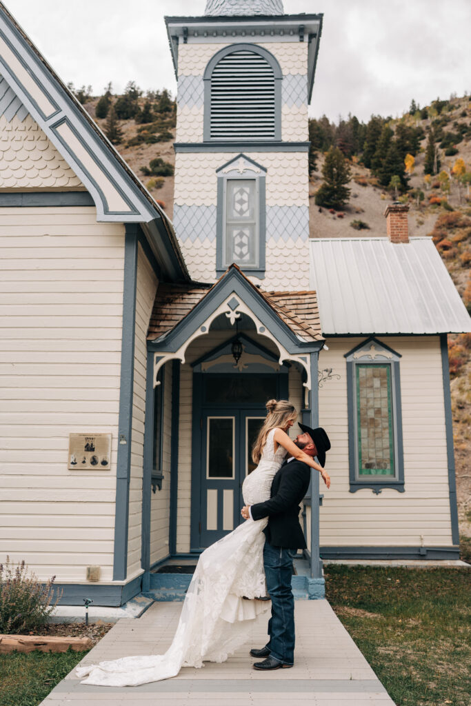 groom lifting bride up as she looks down on him during their lake city colorado elopement