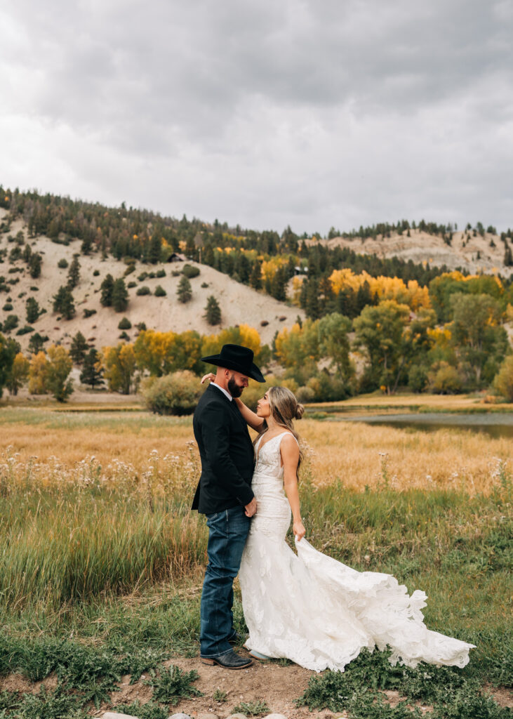 bride and groom facing eachother as bride plays with dress during their lake city colorado elopement