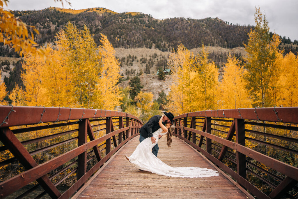 groom dip kissing his bride on a bridge during their lake city colorado elopement