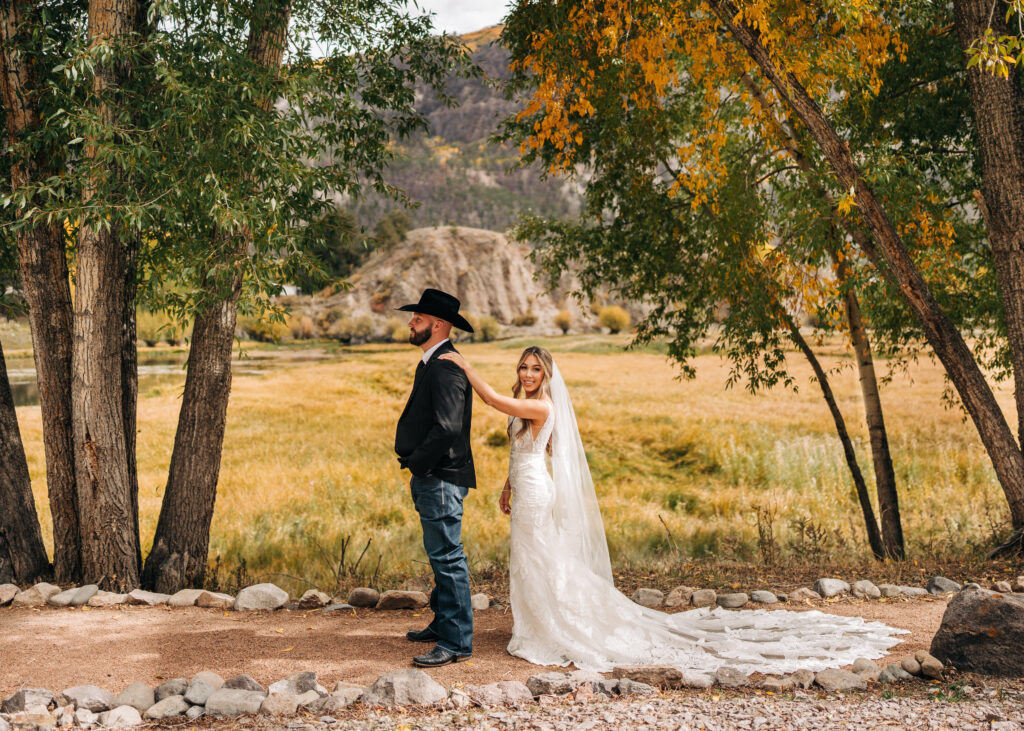 bride tapping groom on the shoulder to surprise him for their first look at their lake city colorado elopement