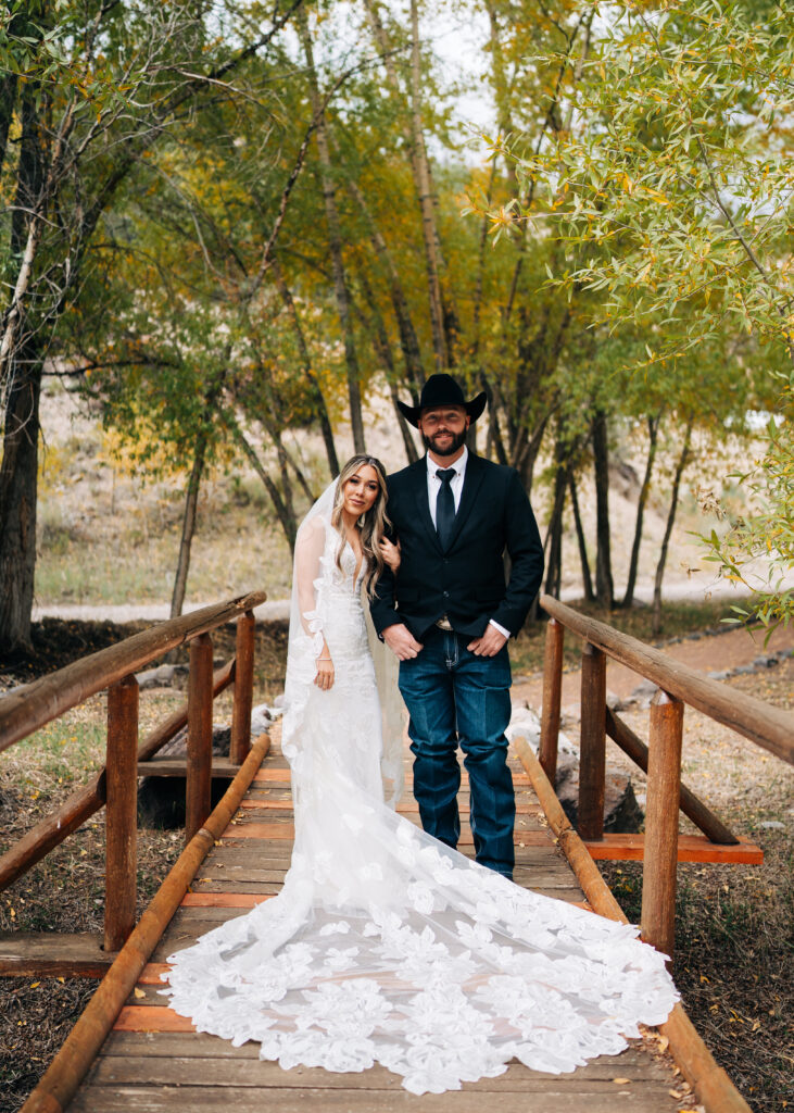 bride and groom standing on a bride smiling at the camera during their lake city colorado elopement