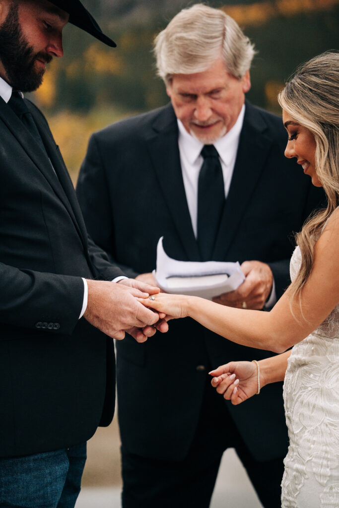 groom putting brides ring on during their lake city colorado elopement