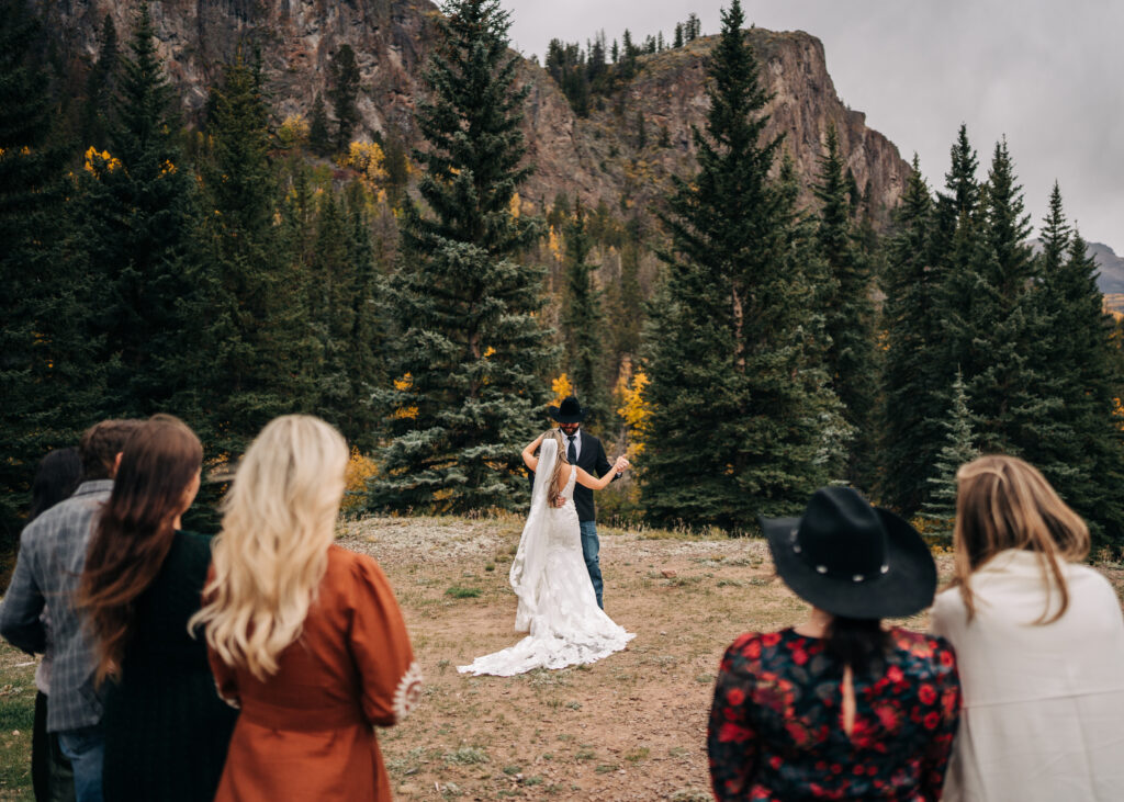 bride and groom sharing their first dance as family watches during their lake city colorado elopement
