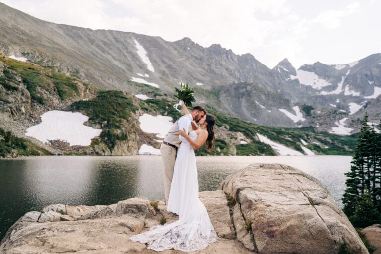 Couple kissing by mountain lake.