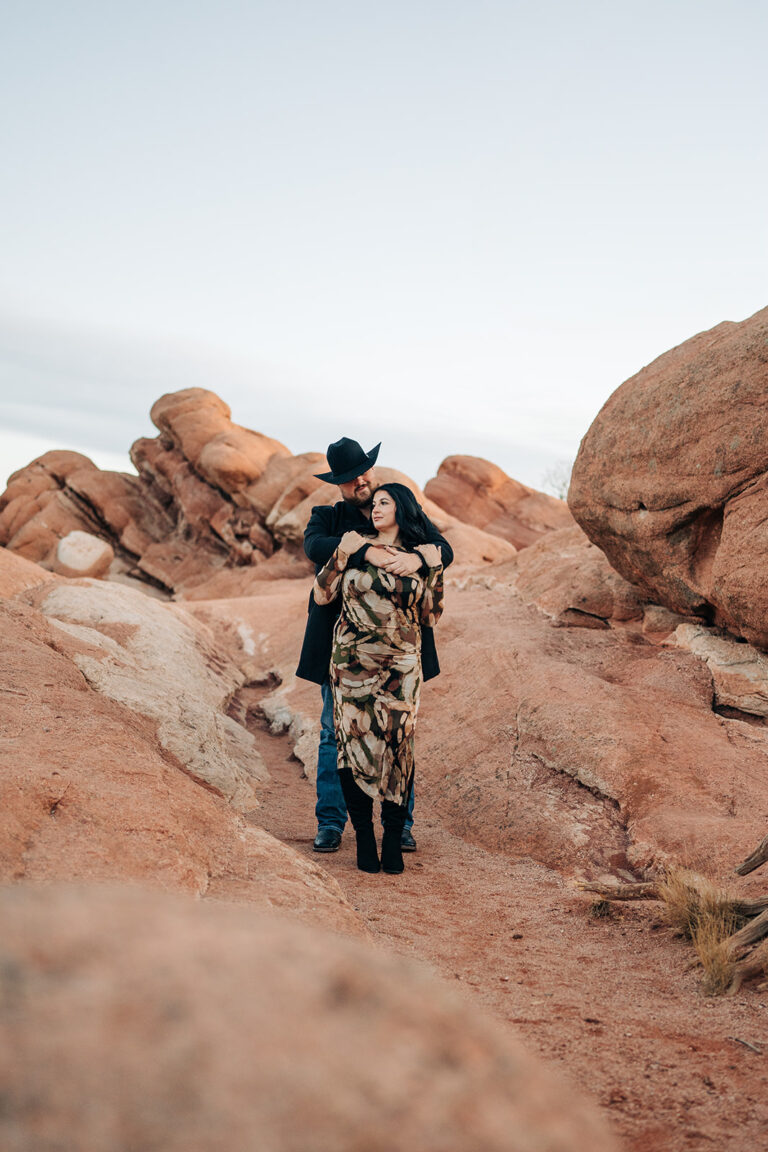 Couple embracing in rocky landscape.