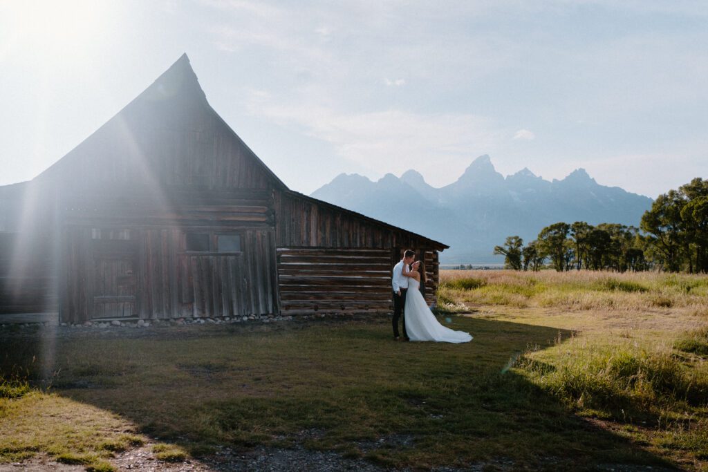 bride and groom standing in front of the barn at mormon row in grand teton national park during their elopement
