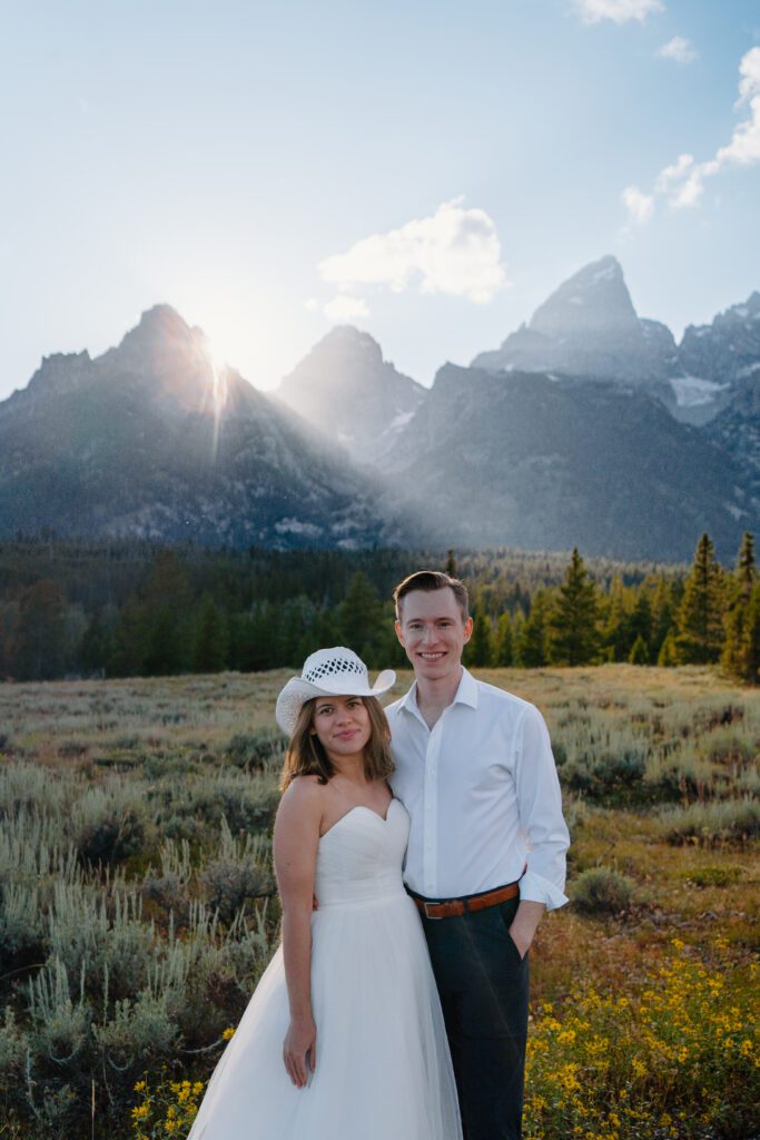 bride and groom snuggled up smiling at the camera in Grand Teton National Park during their Grand Teton elopement
