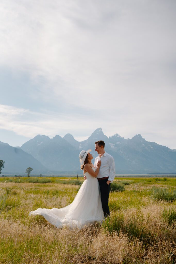 bride and groom smiling at each other in a meadow during their jackson hole elopement in grand tetons national park