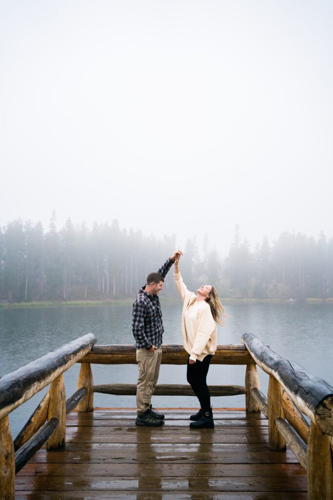 husband and wife dancing on the pier at sprague lake during their rocky mountain national park engagement session