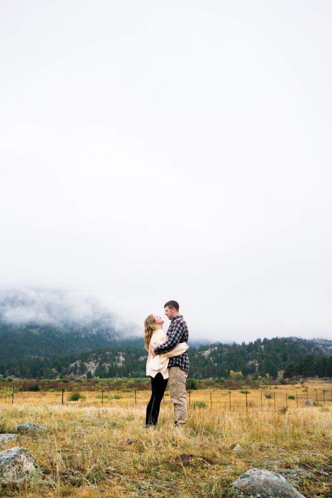 married couple standing in morraine park during their rocky mountain national park engagement photos
