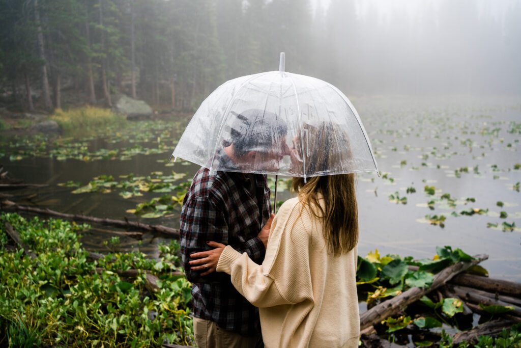 husband and wife kissing in the forest during their rocky mountain national park engagement session