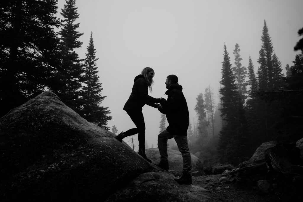 husband and wife walking up a mountain during their rocky mountain national park engagement session