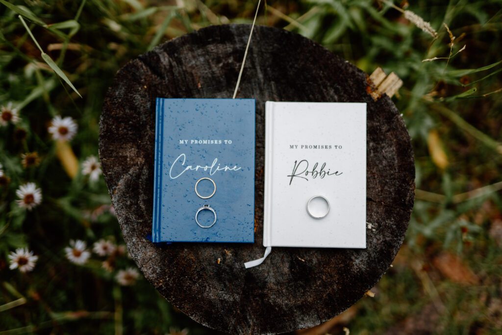bride and groom vow books displayed on a tree trunk during their eldora mountain colorado elopement