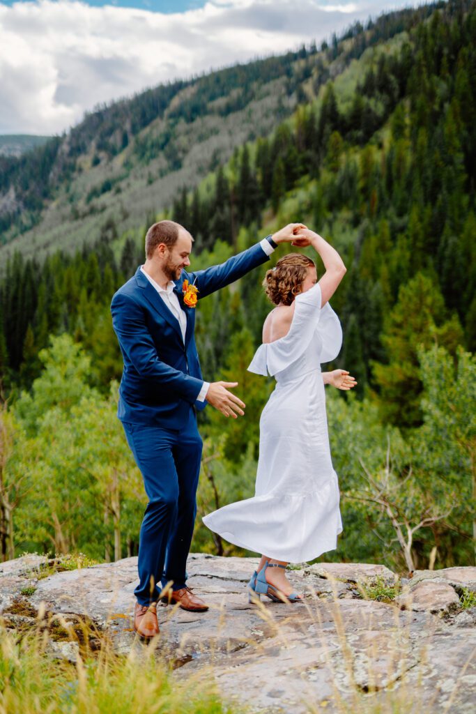 bride and groom dancing on the top of a mountain during their eldora mountain colorado elopement 