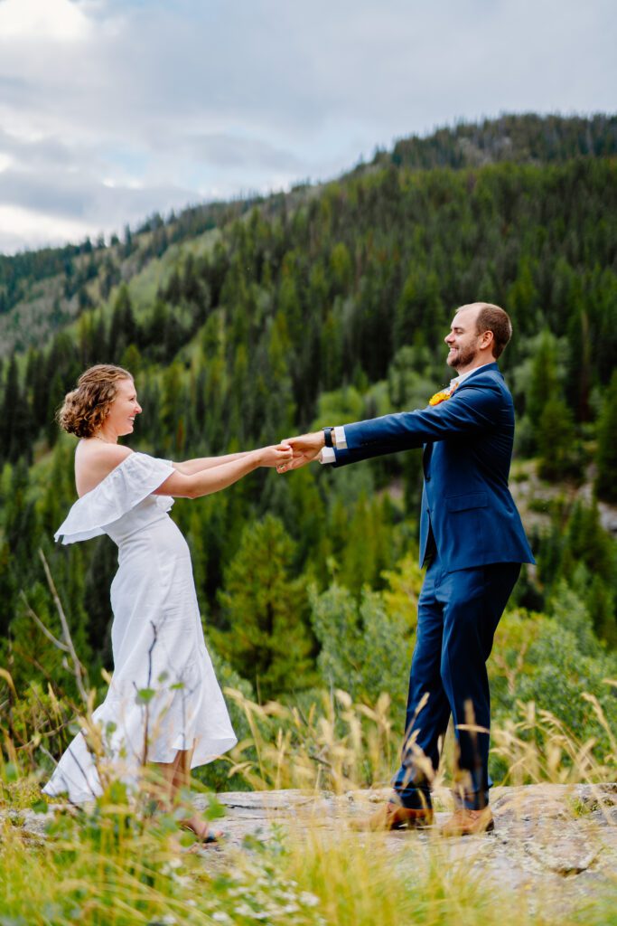 bride and groom dancing on a mountain top during their eldora mountain colorado elopement