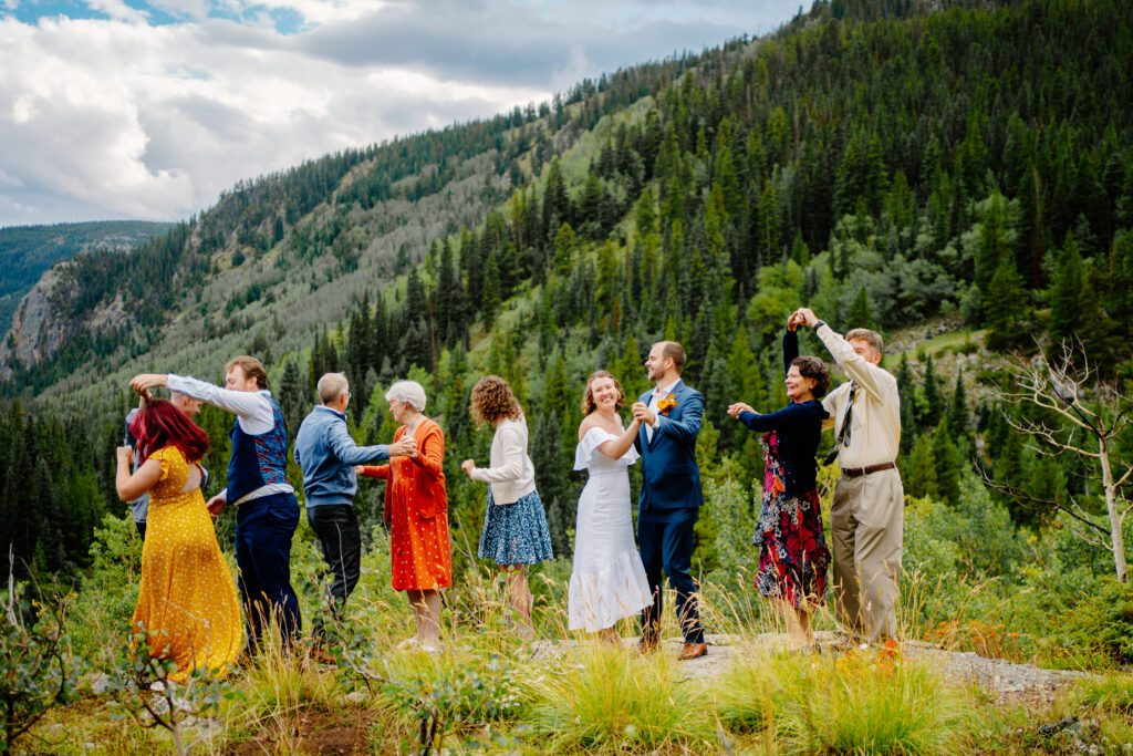 bride and grooms family joining them for a group dance party on top of a mountain during their eldora mountain colorado elopement
