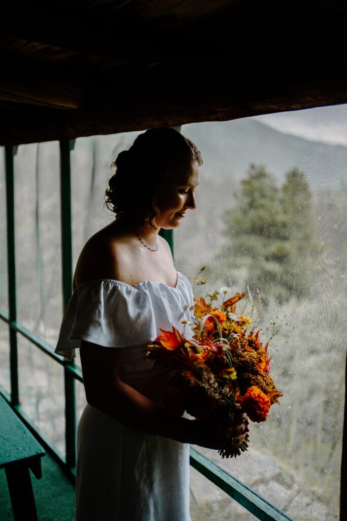 bride looking down at her bouquet before her colorado elopement ceremony