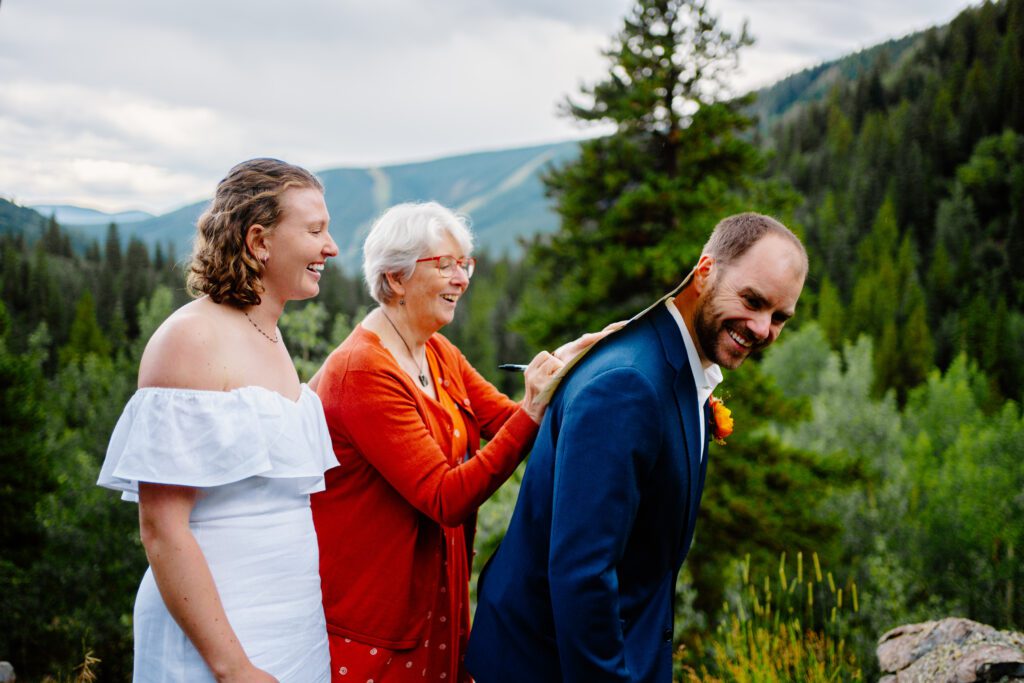 mother of the groom signing the marriage license on his back during his eldora mountain colorado elopement