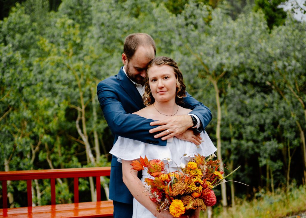 bride smiling at the camera while the groom leans in for a kiss during their eldora mountain colorado elopement