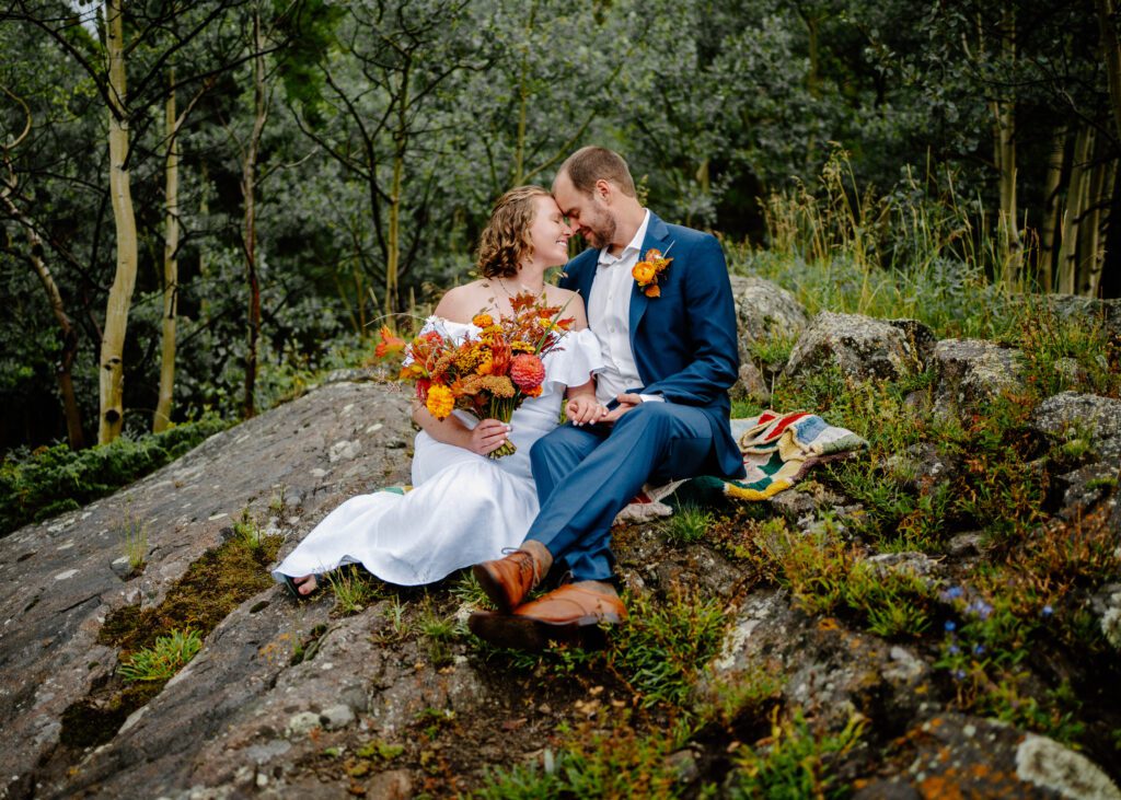bride and groom sitting together on eldora mountain colorado during their elopement