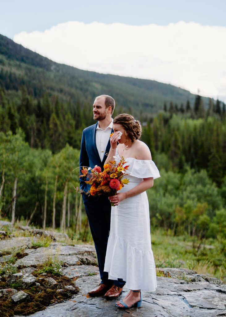 bride crying while family speaks during her elopement ceremony on eldora mountain colorado