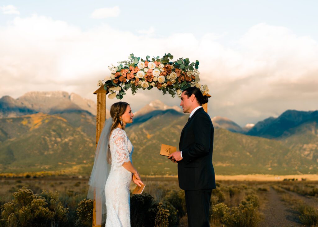 groom listening to the grooms vows with the mountains in the background during their colorado springs elopement
