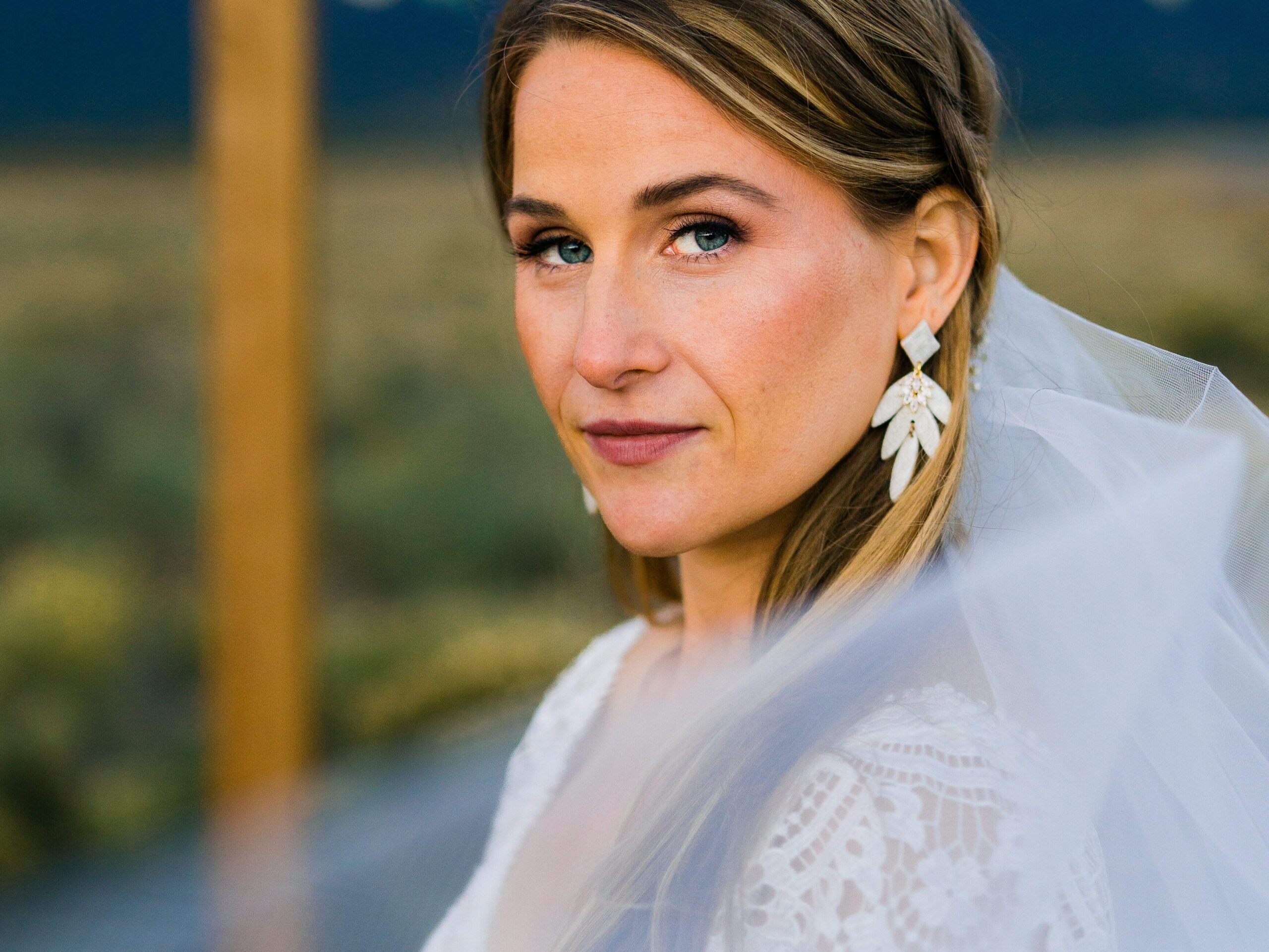 bride smiling at the camera with her veil in the foreground during her colorado springs elopement