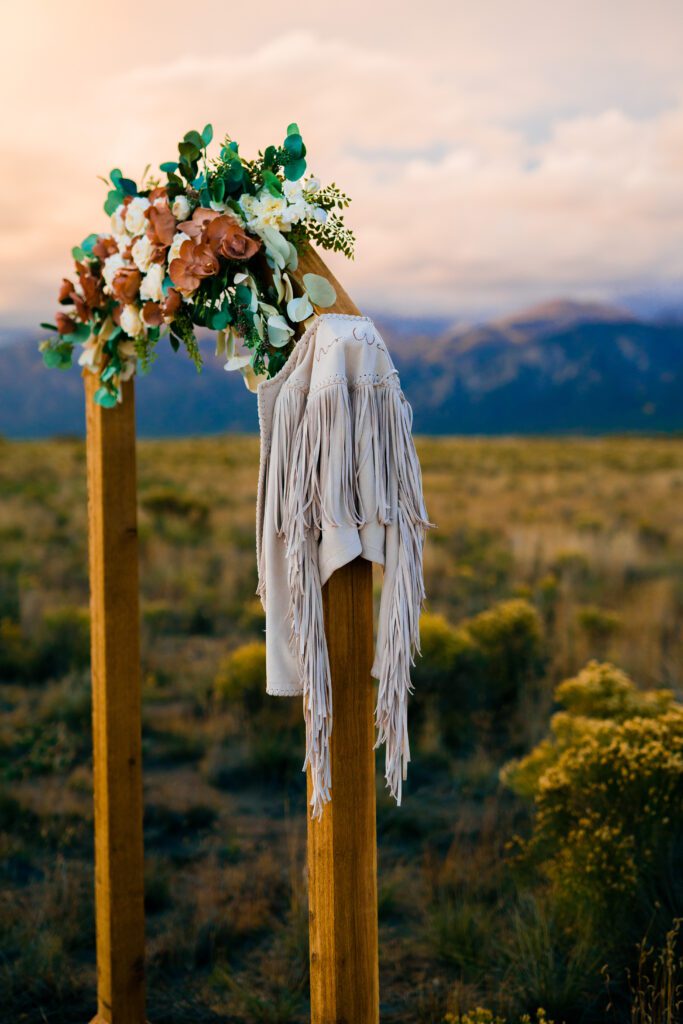 upclose of arbor and brides fringe jacket during a colorado springs elopement