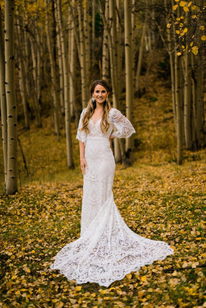 bride smiling at the camera in a field of aspens during her colorado springs elopement
