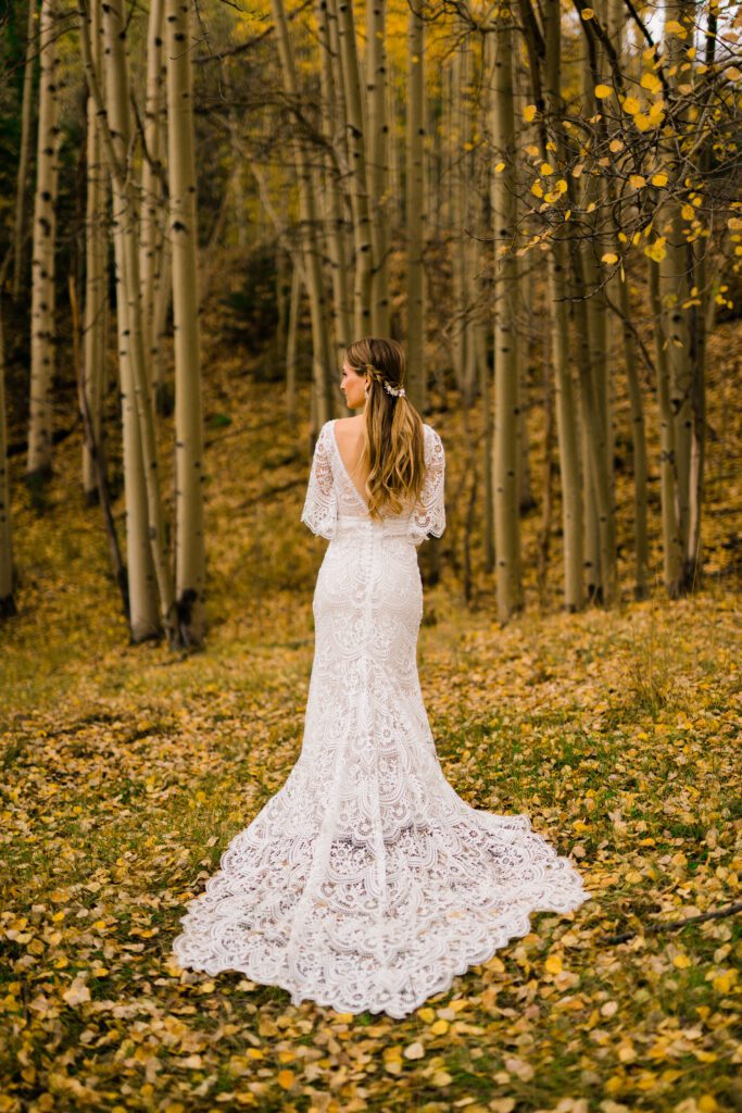 back of the dress with bride looking away from the camera in a field of aspens during colorado springs elopement