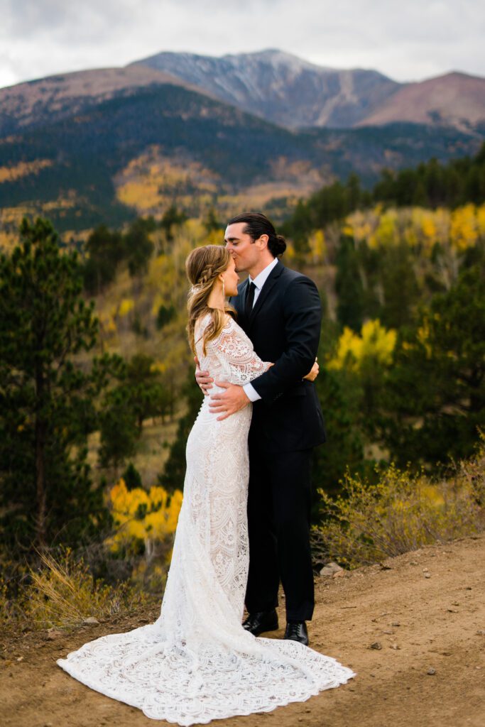 groom kissing the brides forehead and hugging her during their colorado springs elopement