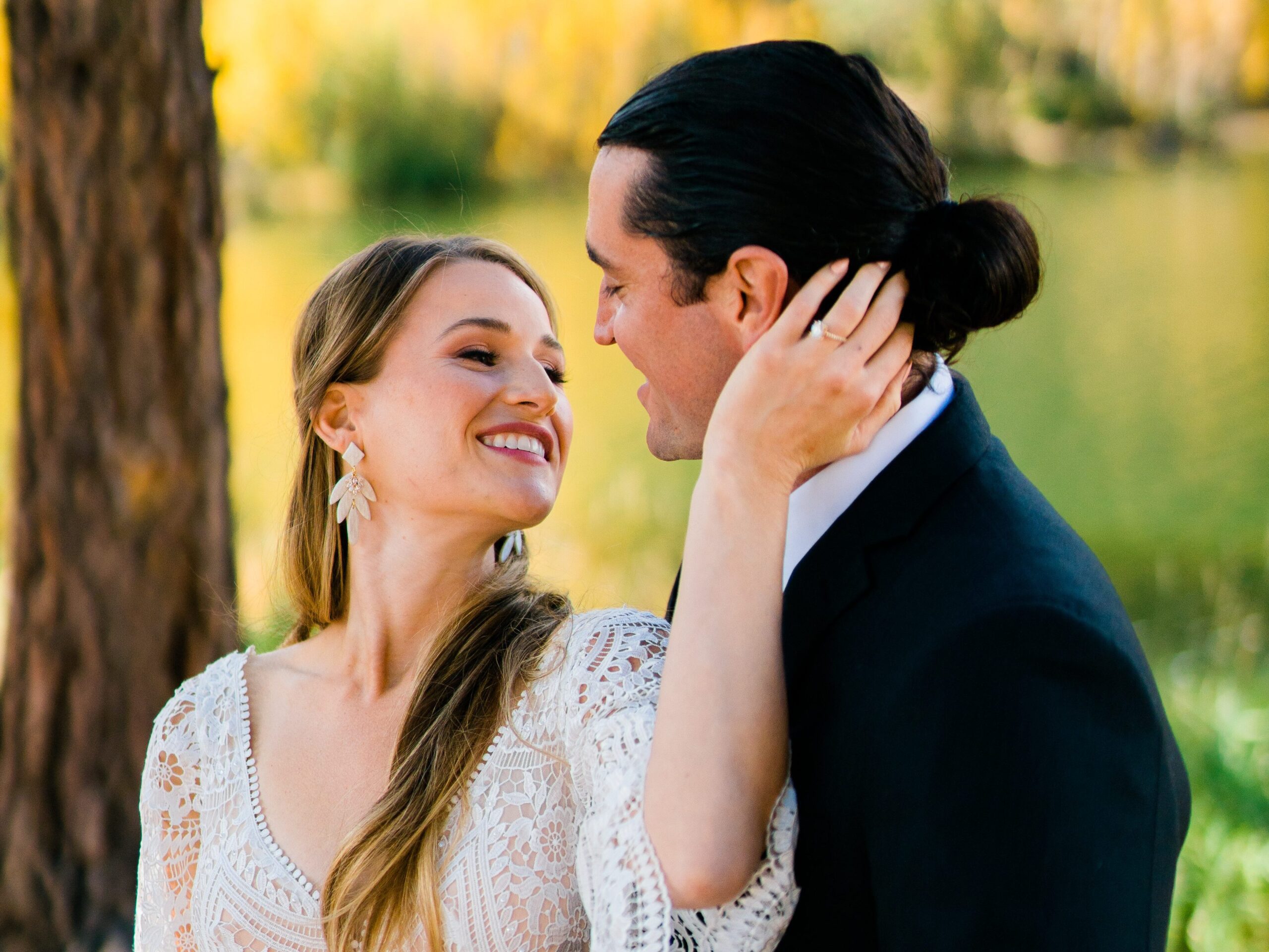 bride holding grooms face while smiling at him during their colorado springs elopement
